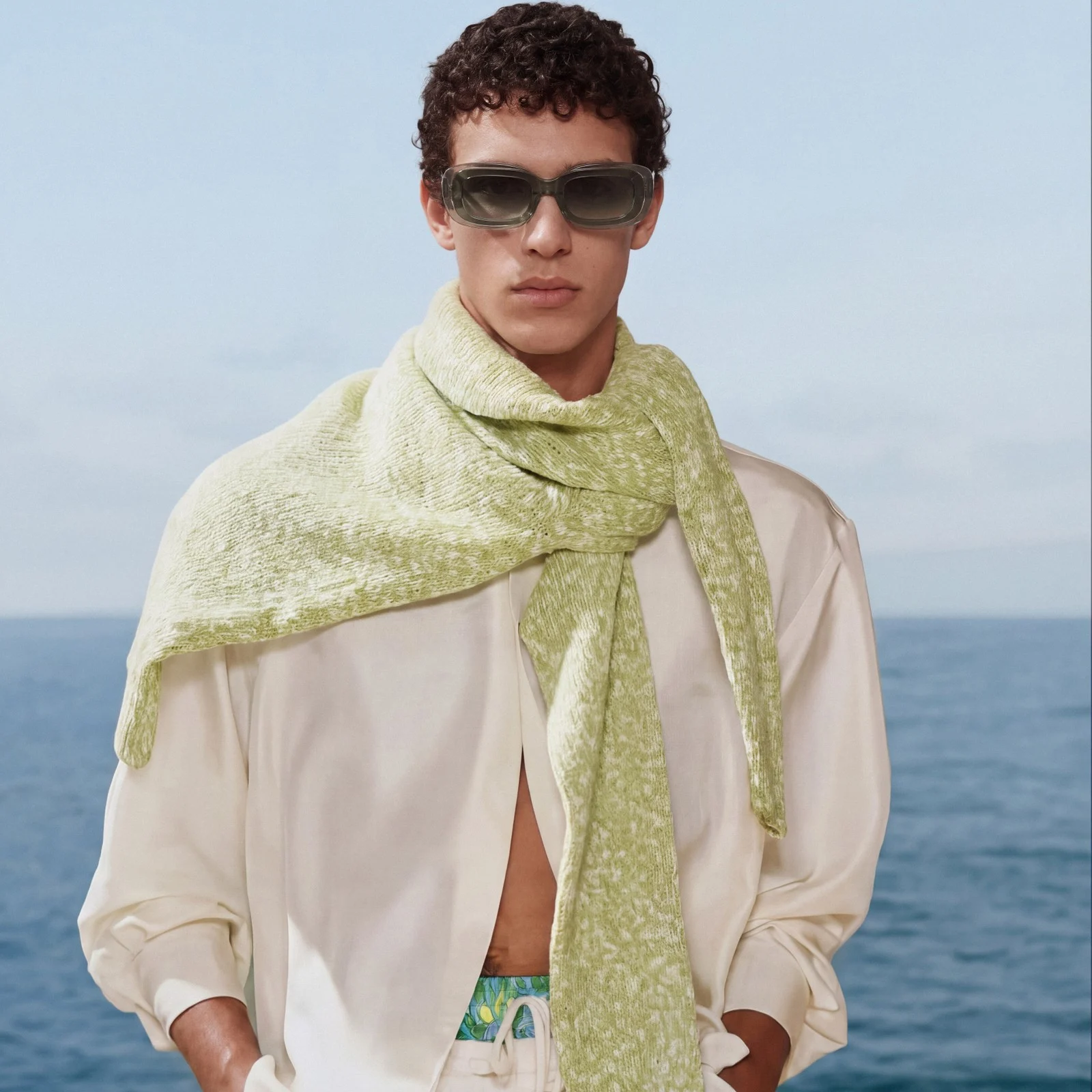 Serene portrait: green scarf, cream shirt and sea air
