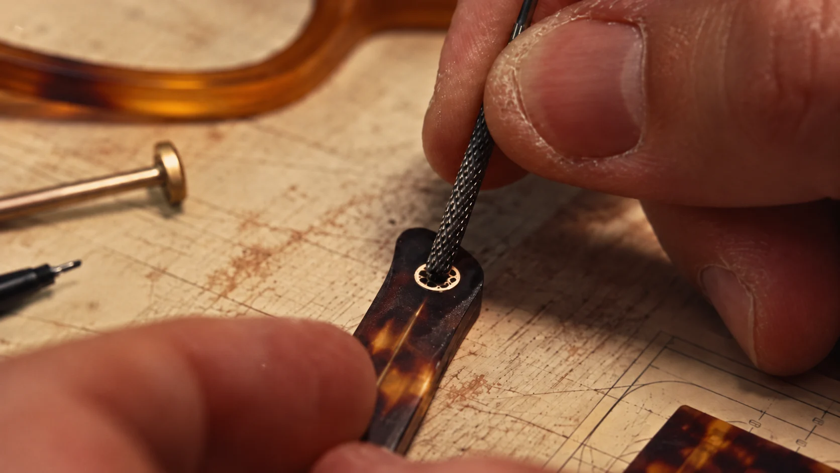 Close detail of an emblem being set into an acetate temple
